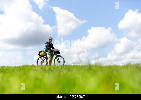 Turista in gita in bicicletta, in bikepacking da Lubiana a Pirano in Slovenia, in bicicletta con borse sulla bicicletta, con tenda e attrezzature Foto Stock