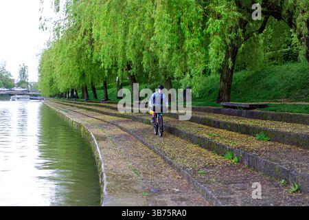Adolescente in un viaggio in bici intorno alla Slovenia, ciclista in bicicletta su una splendida riva del fiume Lubiana a Lubiana, Slovenia Foto Stock