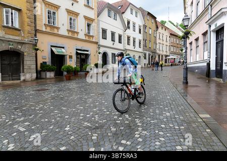 Adolescente in un viaggio in bicicletta per la Slovenia, ciclista in bicicletta intorno alla parte storica vecchia di Lubiana, in Slovenia, esplorando diverse attrazioni turistiche Foto Stock