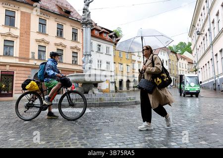Adolescente in un viaggio in bicicletta per la Slovenia, ciclista in bicicletta intorno alla parte storica vecchia di Lubiana, in Slovenia, esplorando diverse attrazioni turistiche Foto Stock