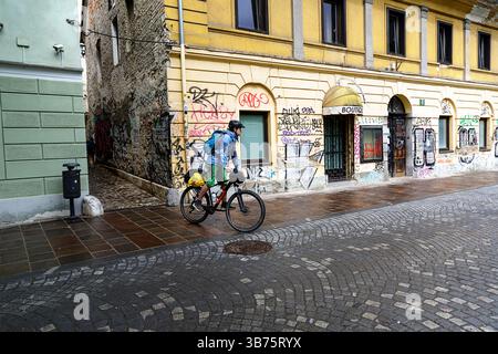 Adolescente in un viaggio in bicicletta per la Slovenia, ciclista in bicicletta sulle strade di ciottoli nella pittoresca parte vecchia di Lubiana, Slovenia Foto Stock
