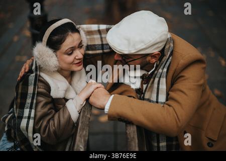 Coppia sorridente che si diverte un momento intimo insieme nella moda autunnale all'aperto Foto Stock