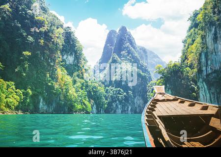 Naviga attraverso gli splendidi paesaggi del lago Cheow LAN in Thailandia su una barca a coda lunga Foto Stock