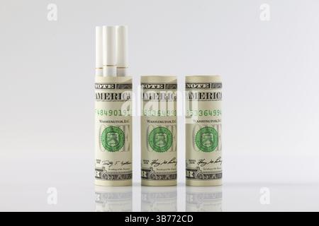 Rotoli di fatture del dollaro e una lunga sigarette Foto Stock