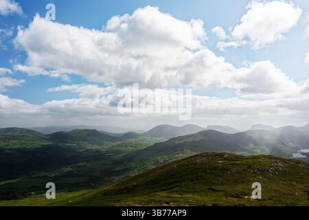Lussureggianti colline verdi si estendono attraverso il paesaggio di Blackvalley, Irlanda, mostrando la splendida bellezza naturale. Le accattivanti nuvole si trascinano pigramente Foto Stock