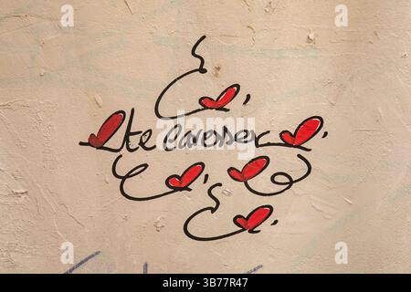 Street art di Montmartre. Te Caresser. Graffiti di cuore sulle mura di Rue Saint-Rustique nel XVIII arrondissement di Parigi, Francia. Foto Stock