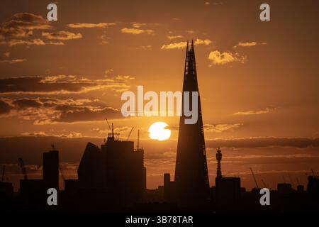 Londra, Regno Unito. 5 maggio 2025. Meteo nel Regno Unito: Tramonto spettacolare vicino all'edificio del grattacielo Shard con il Met Office che prevede che le temperature scenderanno da 22C a circa 15C o 16C nella prossima settimana. Crediti: Guy Corbishley/Alamy Live News Foto Stock