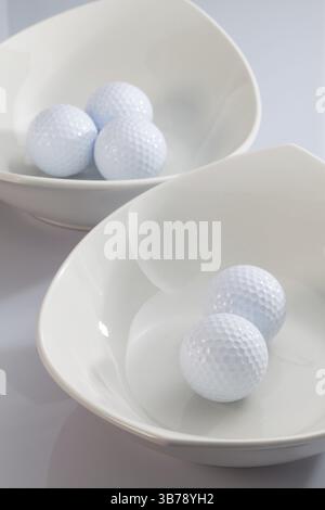 Due ceramiche bianche bocce e palline da golf Foto Stock