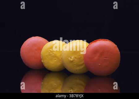 Tradizionale Francese macaron colorati sul vetro nero tabella Foto Stock