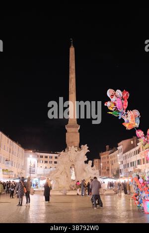 Scena notturna in Piazza Navona a Roma con palloncini colorati illuminati dalle luci di strada e gente in una vivace atmosfera serale in Italia. Foto di alta qualità Foto Stock
