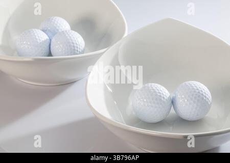 Due ceramiche bianche bocce e palline da golf Foto Stock