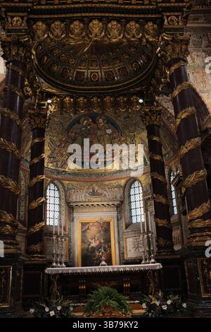 Cappella sopraelevata e tomba scultorea nella basilica di Santa Maria maggiore con ghirlande natalizie dettagliate opere d'arte murale e statue religiose sotto archi architettonici dipinti in oro. Foto di alta qualità Foto Stock