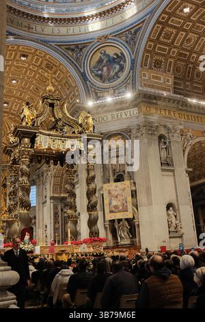 Baldacchino ornato sull'altare papale nella Basilica di San Pietro città del Vaticano progettato da Gian Lorenzo Bernini con colonne in bronzo ritorto decorazioni floreali rosse e iscrizioni latine sotto la grande cupola. Foto di alta qualità Foto Stock