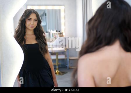 Una donna premurosa siede nel pensiero, le sue emozioni rimangono neutrali. Donna che parla con il parrucchiere mentre si fa i capelli al salone di bellezza. Riprese 4K di alta qualità Foto Stock