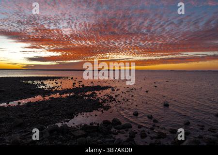 Paesaggio di nuvole e mare con un intenso colore rosso a un'ora d'oro dal Malecón di la Paz, Messico Foto Stock