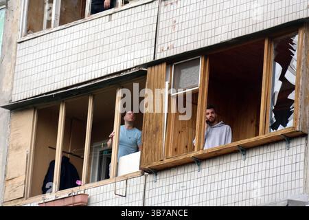 Non esclusiva: I residenti di un condominio danneggiato da un attacco di droni russi liberano il vetro rotto dai loro balconi, quartiere di Obolon, Kiev Foto Stock