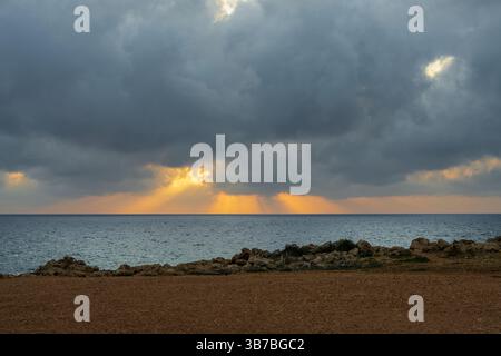 Tramonto sulla costa rocciosa di Peyia, Cipro. Contrasti naturali sorprendenti e atmosfera tranquilla rendono questo luogo ideale per viaggi, natura e relax Foto Stock