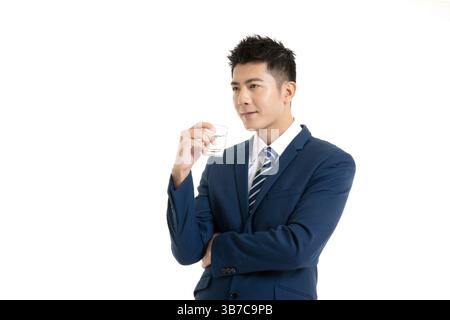 Un professionista dall'abbigliamento impeccabile in ufficio, che regala un bicchiere durante un evento di networking informale. Foto Stock