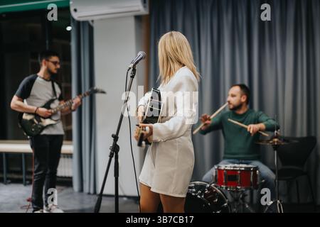Band che praticano la musica insieme in un moderno ambiente da studio Foto Stock