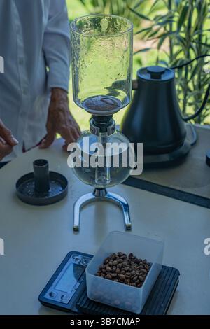 Una macchina per il caffè con sifone e chicchi di caffè su una scala durante un tour di una fattoria di caffè in Colombia. Foto Stock