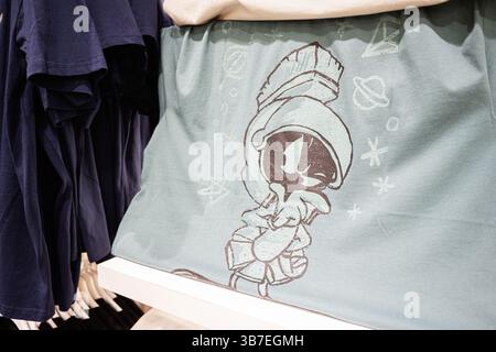 Ivano-Frankivsk, Ucraina - 29 aprile 2025: T-shirt blu con Marvin il design dello spazio dei cartoni animati marziani, presentata in un ambiente di vendita al dettaglio. Foto Stock