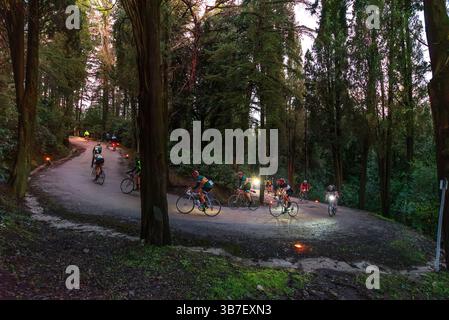 Ciclisti della corsa ciclistica Eroica di fronte ad un tornante lungo la strada che porta al castello di Brolio Foto Stock