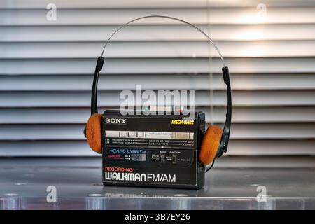 Lettore di cassette portatile Sony vintage con cuffie che riproducono musica, evocando nostalgia degli anni '80 e '90 Foto Stock