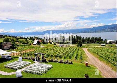 Luogo panoramico per matrimoni all'aperto in un vigneto che si affaccia sul lago Okanagan, circondato da vegetazione lussureggiante e viste sulle montagne in estate. Foto Stock