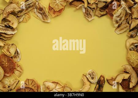 Ornamento ovale costituito da fette sottili di frutta secca su fondo giallo. Foto Stock