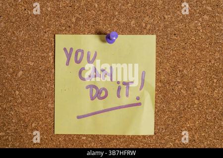 Nota adesiva gialla sul bordo di sughero che dice che puoi farlo. concetto incoraggiante Foto Stock