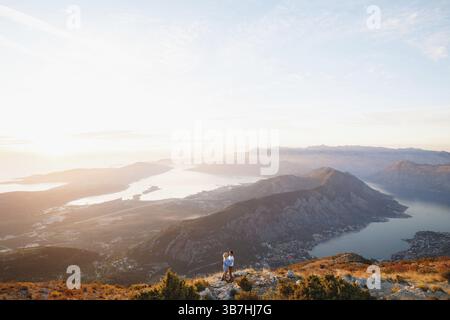 Coppia che abbraccia sullo sfondo del panorama del Monte Lovcen, della Baia di Cattaro, Montenegro. Foto Stock