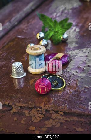 Set di filettature e bottoni su vecchio sfondo in legno Foto Stock