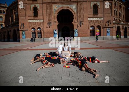 Madrid, Spagna. 6 maggio 2025. Madrid, Spagna. 6 maggio 2025. Un attivista vestito da angelo al centro, circondato da attivisti che simulano tori sanguinosi, protestando. Nel corso di un'azione per i diritti degli animali contro la corrida condotta dall'organizzazione per i diritti degli animali PETA sulla facciata principale dell'arena Las Ventas di Madrid. Crediti: D. Canales Carvajal/Alamy Live News Foto Stock