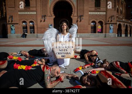 Madrid, Spagna. 6 maggio 2025. Madrid, Spagna. 6 maggio 2025. Un attivista vestito da angelo al centro, circondato da attivisti che simulano tori sanguinosi, protestando. Nel corso di un'azione per i diritti degli animali contro la corrida condotta dall'organizzazione per i diritti degli animali PETA sulla facciata principale dell'arena Las Ventas di Madrid. Crediti: D. Canales Carvajal/Alamy Live News Foto Stock