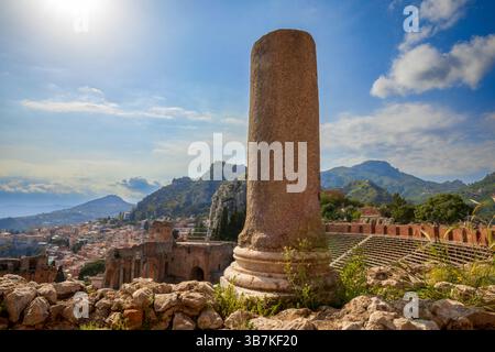 Dettaglio ravvicinato di una colonna dell'antico teatro greco di Taormina, Sicilia, Italia, con viste mozzafiato sulle montagne e sull'Etna. Foto Stock