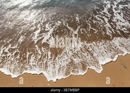 Surf in mare. L'onda corre sulla spiaggia. Foto Stock