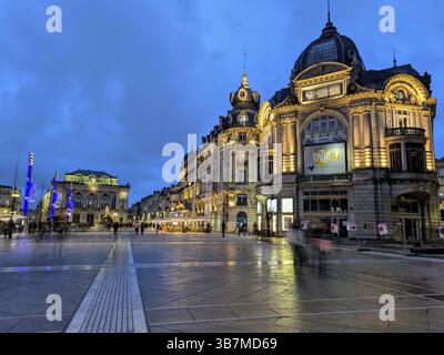 Paesaggio urbano illuminato al crepuscolo con edifici storici e un cielo blu profondo. Montpellier, Herault, Francia, Europa Foto Stock