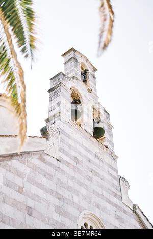 Campane in bronzo del campanile sul tetto della Chiesa della Santissima Trinità. Budva, Montenegro. Foto Stock