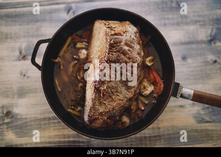 Sul tavolo è presente un succoso roast beef in salsa con verdure. Vista dall'alto. Foto Stock