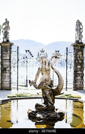 Statua di una sirena nella fontana nel giardino di fronte al cancello. Villa Monastero, Italia. Foto Stock