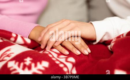 La coppia giapponese tiene le mani bere il caffè di Natale a casa Foto Stock