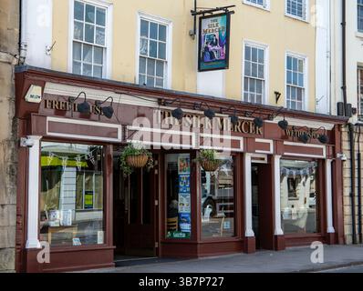 Facciata di un pub Wetherspoons, il Silk Mercer, in un edificio storico con piante appese e grandi finestre in una giornata di sole a Devizes Wiltshire. Foto Stock
