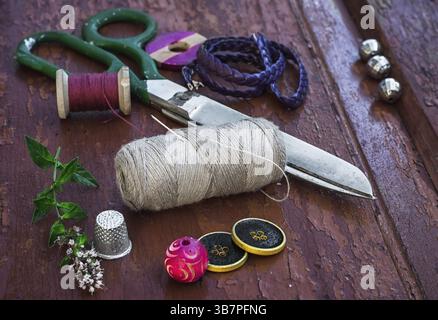 Set di filettature e bottoni su vecchio sfondo in legno Foto Stock