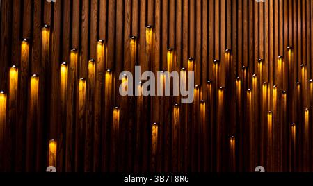 Parete con spranghe in legno e illuminazione Foto Stock