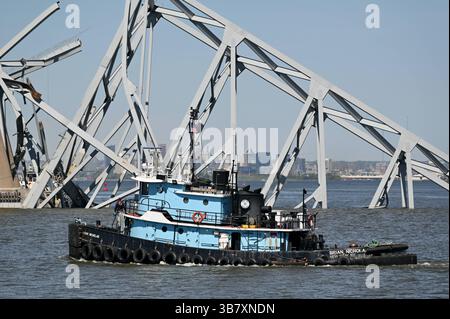 16 aprile 2024, Dundalk, MD, Stati Uniti d'America: Un rimorchiatore passa una capriata d'acciaio dal crollato Francis Scott Key Bridge bloccando il canale di Fort McHenry, 16 aprile 2024, vicino a Dundalk, Maryland. Il ponte fu colpito dalla nave portacontainer di 984 piedi il 26 marzo e crollò uccidendo sei lavoratori. (Immagine di credito: © Mdgovpics/Maryland Governor/Planet Pix via ZUMA Press Wire) Foto Stock