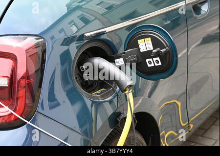 Ein Elektro PKW von FIAT steht an einer Ladesäule, Ladevorgang an einer Ladesäule für e-Autos. Ein Elektroauto dispone di un einer Ladestration auf einem Parkplatz geladen, Ladekabel im Ladestecker Ladestation Schnellladestation Ladesäule Ladepunkt für Elektroauto Elektromobilität e-Auto aufladen Ladestecker Ladekabel Fahrzeugstecker Strom Stromauto Stromer Stromsäule Stromtankstelle Elektrizität Elektro-Mobilität Foto Stock