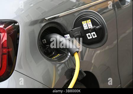 Ein Elektro PKW von FIAT steht an einer Ladesäule, Ladevorgang an einer Ladesäule für e-Autos. Ein Elektroauto dispone di un einer Ladestration auf einem Parkplatz geladen, Ladekabel im Ladestecker Ladestation Schnellladestation Ladesäule Ladepunkt für Elektroauto Elektromobilität e-Auto aufladen Ladestecker Ladekabel Fahrzeugstecker Strom Stromauto Stromer Stromsäule Stromtankstelle Elektrizität Elektro-Mobilität Foto Stock