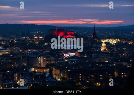 Il Castello di Edimburgo è illuminato di rosso, dato che i monumenti storici di tutto il Regno Unito sono illuminati per il 80° anniversario del VE Day. Data foto: Martedì 6 maggio 2025. Foto Stock