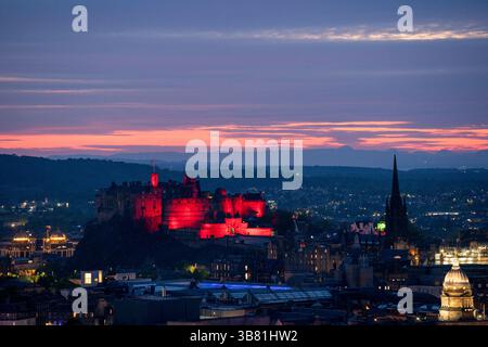 Il Castello di Edimburgo è illuminato di rosso, dato che i monumenti storici di tutto il Regno Unito sono illuminati per il 80° anniversario del VE Day. Data foto: Martedì 6 maggio 2025. Foto Stock