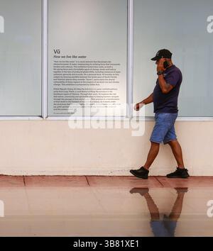 11 giugno 2024, Miami Beach, FL: Alcune delle opere di Vu HoÃÂ ng KhÃÂnh NguyÃÂªn sono assenti nelle vetrine del Walgreens a North Beach dopo che il Consiglio di amministrazione dell'organizzazione no profit Oolite Arts ha rimosso l'installazione Ã¢â‚¬Å“How We live like water.Ã¢â‚¬Â Un passante navigando sul marciapiede allagato dove l'installazione è stata esposta martedì 11 giugno 2024, a Miami Beach, Florida. (Immagine di credito: © Carl Juste/Miami Herald tramite ZUMA Press Wire) Foto Stock